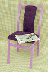 Оставленные газета и очки лежат на стуле