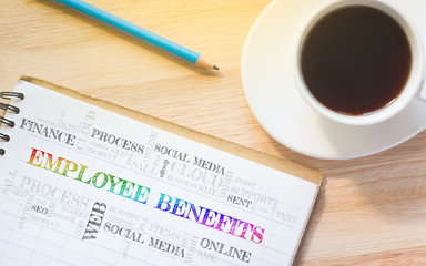 Concept EMPLOYEE BENEFITS message on book. A pencil and a glass coffee table.Vintage tone.