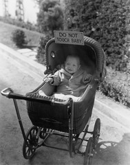 Baby with sign saying do not touch baby 