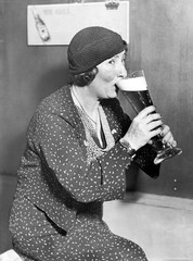 Kobieta pije z dużego szklanego piwa - 104441606