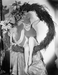 Circling in on the devil, a young woman sits in a wreath 