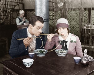 Couple sharing a noodle in a restaurant  