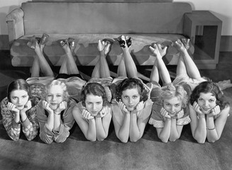 Portrait of young women in row on floor 