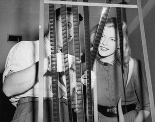 Man with his assistant looking at film reels 