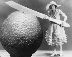 Woman with huge knife and piece of fruit 