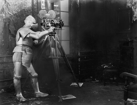 Knight at the movies, a man in an armored suit uses a film camera 