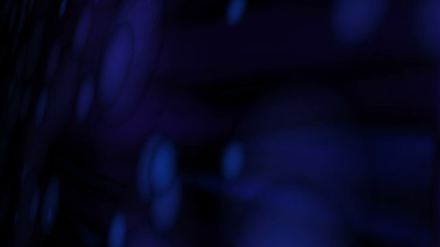 Blue violet orbs stream across the screen against a dark background. Looping.
