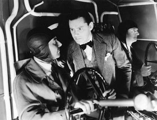 Three men inside of the cockpit of an airplane 