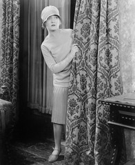 Young woman looking surprised behind a curtain 