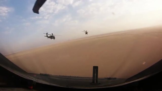 A squadron of helicopters fly in formation over Afghanistan.