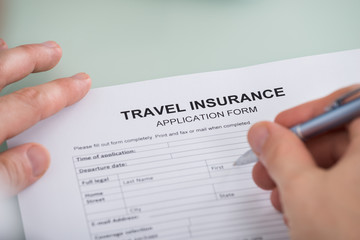 Person Hand Over Travel Insurance Application Form