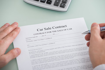 Person Filling Car Sale Contract Form