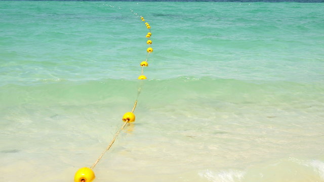 Yellow buoy with wave on the beach 