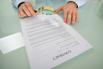 Person's Hand Looking At Contract