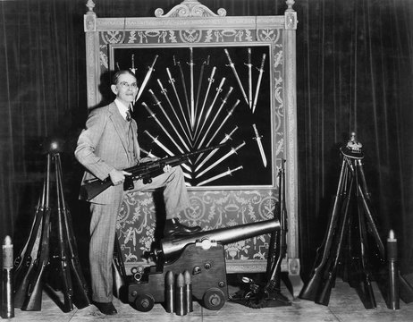 Man posing with guns and cannons 