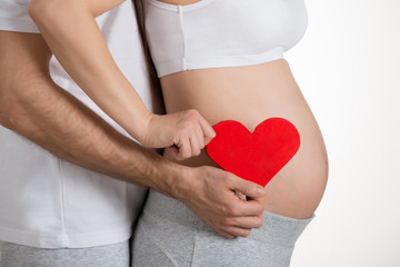 Pregnant Woman With Husband Holding Heart Shape