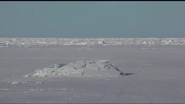 A submarine surfaces through sea ice in the Arctic.