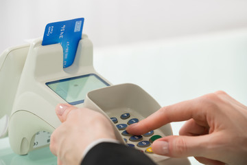 Woman Pressing Button On Credit Card Machine