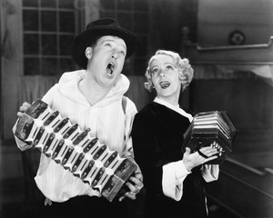 Couple singing while playing two accordions 