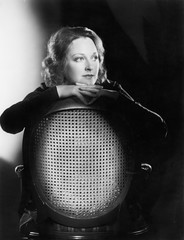 Woman leaning over the back of a chair 