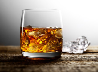 whiskey with ice on a wooden background