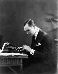 Portrait of man using typewriter 