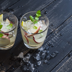 Apple, lemon and mint homemade lemonade on a dark wooden background