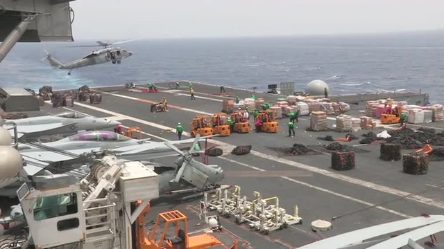 The deck of a U.S. aircraft carrier is prepared for a humanitarian airlift.