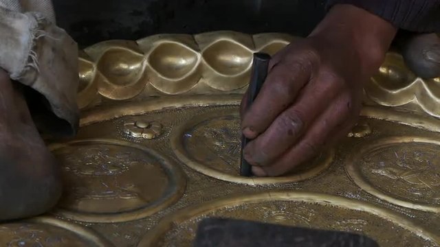 Up close view of hammer, chisel and brass plate