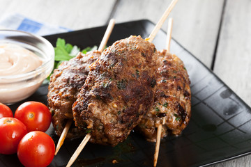 Barbecued kofta with vegetables on a plate