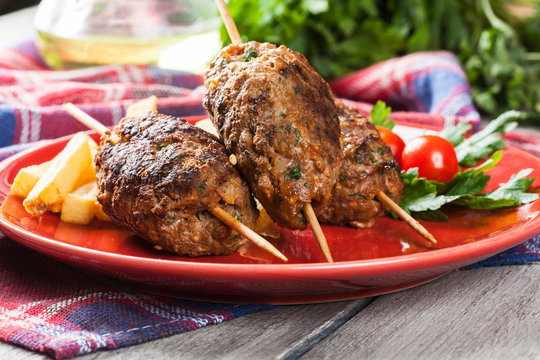 Barbecued kofta with fries on a plate