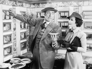 Man serving a dish to a woman in a Automat 
