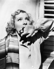Portrait of a young woman looking in fear with her hand over her mouth 