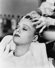 Hairdresser cleaning hair of a young woman in a hair salon 