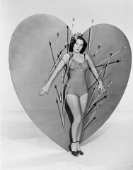 Woman surrounded by arrows on huge heart  - 104456270