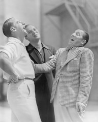 Three men standing together and laughing 