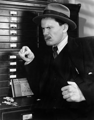 Man looking sternly at a piece of puzzle 