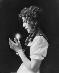 Portrait of woman holding lit candle 