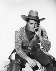 Cowboy with a cowboy hat smoking a cigarette 