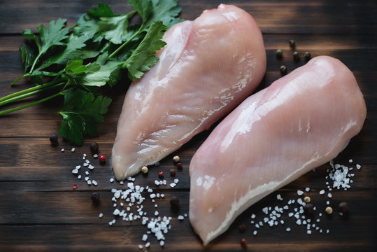 Fresh uncooked chicken breast fillets on a rustic wooden surface