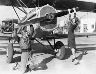Couple playing with propeller on plane 