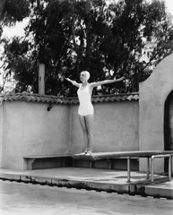 Fotobehang Vrouw op duikplank bij zwembad © everettovrk