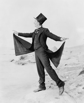 Playful man formally dressed on beach 
