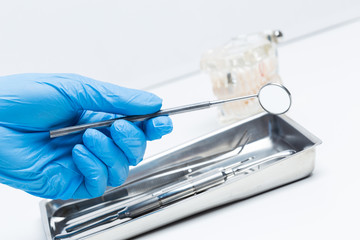 Gloved hand holding dental tools