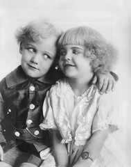 Portrait of a boy and girl with arm around her 