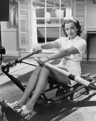 Woman using rowing machine  © everettovrk
