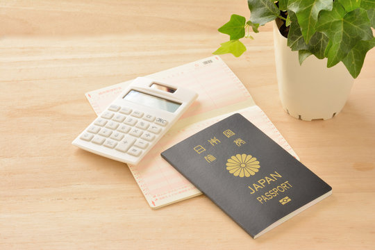 パスポートと通帳と電卓　木目背景