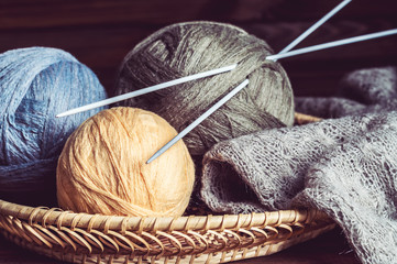 tangles of of woolen yarn and knitting needles in a basket