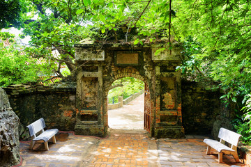 Old stone gate leading into enigmatic tropical garden