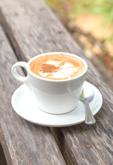 A Cup of coffee on wooden table in the garden